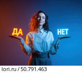 Молодая женщина стоит держа в руках светящиеся слова "ДА" и "НЕТ", символизируя выбор и принятие решений. Стоковое AI-изображение, AI-художник ArtVladZ / Фотобанк Лори