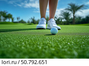 Golf Ball on Green With Player Preparing for Putt at Sunny Course. Стоковое фото, фотограф Юлия Гапеенко / Фотобанк Лори