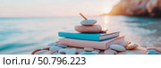 Tranquil Seascape with Stacked Stones and Books at Sunset. Стоковое AI-изображение, AI-художник Данила Большаков / Фотобанк Лори