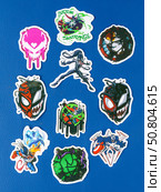 Novosibirsk, Russia - March 1, 2025: Cartoon-style vinyl stickers featuring Venom in various comic book situations on a bright blue background. Редакционное фото, фотограф Виталий Сова / Фотобанк Лори