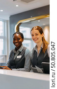 Smiling female receptionists at modern office front desk. Стоковое AI-изображение, AI-художник Olga Didraga / Фотобанк Лори
