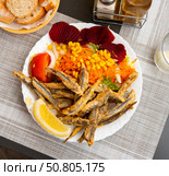 Dish with fried sardines, pilchards or anchovies in batter for traditional Spanish meal. Стоковое фото, фотограф Яков Филимонов / Фотобанк Лори