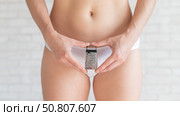 Unrecognizable woman in white panties holds in hands a mini grater. Metaphor of the bristles after depilation in the bikini area of the girl. Spiky hair is an argument for epilation. Стоковое фото, фотограф Михаил Решетников / Фотобанк Лори