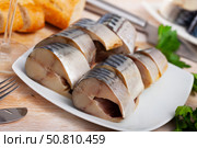 Lightly salted mackerel cut into pieces with parsley on table. Стоковое фото, фотограф Яков Филимонов / Фотобанк Лори