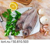 Two raw megrims on wooden table with condiments. Стоковое фото, фотограф Яков Филимонов / Фотобанк Лори