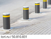Дорожный блокиратор в виде выдвижных металлических столбов. The barrier is automatic in a parking lot in a modern city. Стоковое фото, фотограф Татьяна Д / Фотобанк Лори