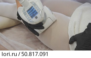 In clinic, cosmetologist uses vacuum roller device with manipulator to perform anti-cellulite massage of client's thighs. Стоковое видео, видеограф Strunov David / Фотобанк Лори