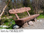 Ala-Archa Park, Handcrafted log bench positioned beside gravel hiking path in alpine woodland. Scenic resting spot for backpackers, mountaineers. Nature exploring remote backcountry terrain. Стоковое фото, фотограф Андрей Ка / Фотобанк Лори