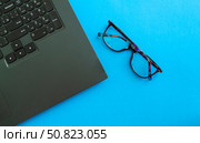 Desktop. Laptop and glasses on a blue background. Стоковое фото, фотограф Юлия Николаева / Фотобанк Лори