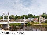 Old town view featuring Pedestrian bridge over Tvertsa river under cloudy sky. Редакционное фото, фотограф EugeneSergeev / Фотобанк Лори