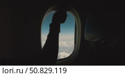 Passenger opens airplane window shade, revealing blue sky and white clouds, transition from darkness to daylight inside aircraft cabin, woman hand lifts blind, comfortable seat, view above the clouds. Стоковое видео, видеограф Сергей Тимофеев / Фотобанк Лори