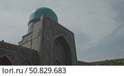 Colorful facade of Islamic madrasa with intricate geometric mosaics and traditional oriental architecture in Samarkand Uzbekistan under blue sky, arched entrance, tile ornament with Arabic calligraphy. Стоковое видео, видеограф Сергей Тимофеев / Фотобанк Лори