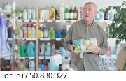Senior man studies label and choose shower cosmetic present, packaged in basket. Стоковое видео, видеограф Яков Филимонов / Фотобанк Лори