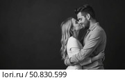 Beautiful couple in love hugging against black background. Studio black and white portrait shot of a girl blondes and a guy with short hair. Valentine's day. Loving married couple. Стоковое AI-видео, аниматор Sergey Grishin / Фотобанк Лори