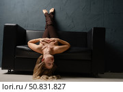 Blonde woman poses gracefully on a couch in a studio setting. Стоковое фото, фотограф Гурьянов Андрей / Фотобанк Лори