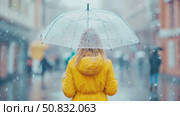 Woman in yellow coat under an umbrella in a snowfall. Стоковое AI-видео, аниматор Данила Большаков / Фотобанк Лори