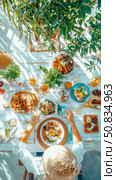Sun-Drenched Brunch: Overhead View of Person at Table Laden with Food, Plants, and Refreshments for a Delicious Summer Feast. Стоковое AI-изображение, AI-художник Данила Большаков / Фотобанк Лори