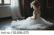 Girl in a chic long dress sitting on the floor. White wedding dress on the bride's body. Beautiful light dress with a long hem, a portrait of fragile delicate girl before the wedding day. Honey moon. Стоковое AI-видео, аниматор Sergey Grishin / Фотобанк Лори