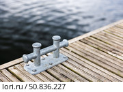 Closeup Of Dock Cleat On Wooden Pier Over Calm Waterfront. Стоковое фото, фотограф EugeneSergeev / Фотобанк Лори