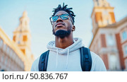 Portrait of a Man with dreadlocks and glasses looking up at the building. Стоковое AI-изображение, AI-художник Данила Большаков / Фотобанк Лори