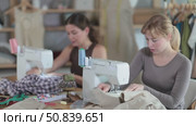 Female seamstresses working at sewing machines in tailoring studio. Стоковое видео, видеограф Яков Филимонов / Фотобанк Лори