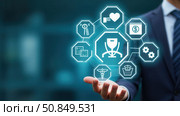 Employee Benefits and Compensation Strategy Concept. Businessman presents employee benefits options on a digital interface. Icons various benefits such as healthcare, insurance. Стоковое AI-изображение, AI-художник Sergey Grishin / Фотобанк Лори