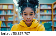 Teen Spirit: Portrait of Student in Library Wearing Yellow Hoodie. Стоковое AI-изображение, AI-художник Данила Большаков / Фотобанк Лори