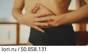 Closeup of a woman midriff as she holds her belly during breathing exercises warmup movements. Стоковое видео, видеограф Igor Tichonow / Фотобанк Лори