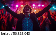 Triumph & Celebration: A man celebrates in a ecstatic crowd, bathed in neon lights, arms raised in victory at a performance venue. Стоковое AI-изображение, AI-художник Данила Большаков / Фотобанк Лори