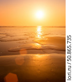 A colorful sunset or sunrise on the seaside with a sandy beach with impurities of volcanic ash. Mandrem, Goa, India. (2018 год). Стоковое фото, фотограф Емельянов Евгений Викторович / Фотобанк Лори