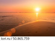 A colorful sunset or sunrise on the seaside with a sandy beach with impurities of volcanic ash. Mandrem, Goa, India. (2018 год). Стоковое фото, фотограф Емельянов Евгений Викторович / Фотобанк Лори