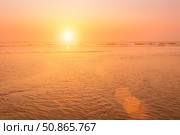 A colorful sunset or sunrise on the seaside with a sandy beach with impurities of volcanic ash. Mandrem, Goa, India. (2018 год). Стоковое фото, фотограф Емельянов Евгений Викторович / Фотобанк Лори