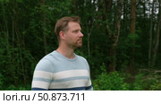 Handsome young man standing outdoors. Male thinking looking around feel happy, calm and serious. Green park background. Guy business employer, businessman manager inspired in nature. Diversity People. Стоковое видео, видеограф Марина Демидюк / Фотобанк Лори