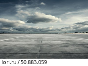 Expansive concrete surface under dramatic sky. Стоковое AI-изображение, AI-художник Иван Рябоконь / Фотобанк Лори