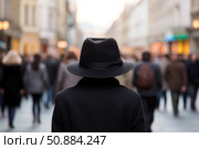 Elegant man wearing black hat walking in a crowded street. Стоковое AI-изображение, AI-художник Иван Рябоконь / Фотобанк Лори