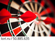 Red dart flying towards dartboard with other darts already hitting target. Стоковое AI-изображение, AI-художник Иван Рябоконь / Фотобанк Лори