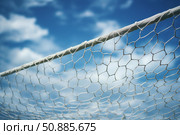 Soccer goal netting framing a cloudy blue sky. Стоковое AI-изображение, AI-художник Иван Рябоконь / Фотобанк Лори