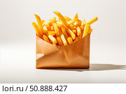 French fries overflowing from brown paper bag on white background. Стоковое AI-изображение, AI-художник Иван Рябоконь / Фотобанк Лори