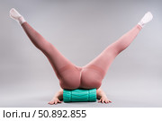 Fat woman in sportswear use myofascial release massage mfr roll on gray background, pelvic floor muscle exercise. Стоковое фото, фотограф Станислав Тарко / Фотобанк Лори