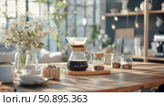 Morning Brew Ritual: A still life capturing the art of coffee preparation and the tranquility of a bright, sun-drenched breakfast nook. Стоковое AI-изображение, AI-художник Данила Большаков / Фотобанк Лори