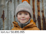 Portrait of smiling child wearing winter clothes and beanie with orange pompom. Стоковое AI-изображение, AI-художник Иван Рябоконь / Фотобанк Лори
