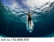 Diver gracefully enters water, creating splash under bright blue sky with rippling surface. Стоковое AI-изображение, AI-художник Гайфуллина Дина / Фотобанк Лори