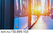 Sleek blue city tram waiting at a sunlit platform, showcasing urban transit at golden hour. Стоковое AI-видео, аниматор Данила Большаков / Фотобанк Лори
