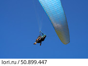 Flight of a passenger with an instructor on a paraglider. Fragment of a wing on a blue background. Стоковое фото, фотограф Роман Дзюбало / Фотобанк Лори