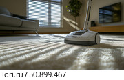 Vacuum cleaner in living room brightened by morning sunlight. Стоковое AI-изображение, AI-художник Katsiaryna Repich / Фотобанк Лори