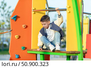 Little boy climbs in rope park or children playground at sunny day. Agility and climbing outdoor amusement center for children. Childhood and sport concept. High quality photo. Стоковое фото, фотограф Ирина Михайличенко / Фотобанк Лори