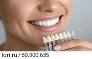 Choosing the perfect dental shade during a cosmetic consultation session. Стоковое AI-изображение, AI-художник Katsiaryna Repich / Фотобанк Лори