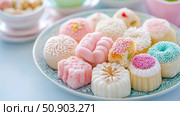 Delicious confectionery art: A plate of assorted petit fours and sweets with pastel color scheme, great for dessert, teatime treats. Стоковое AI-изображение, AI-художник Данила Большаков / Фотобанк Лори