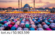 Eid Al-Adha: Congregation of People in Prayer at Sunset with Mosque. Стоковое AI-изображение, AI-художник Данила Большаков / Фотобанк Лори
