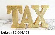 Wooden letters spelling out the word tax are arranged on a smooth marble surface. Стоковое AI-изображение, AI-художник Данила Большаков / Фотобанк Лори